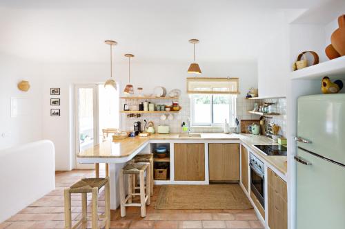 a kitchen with a counter and a refrigerator at Casa dos Avos in Santa Luzia