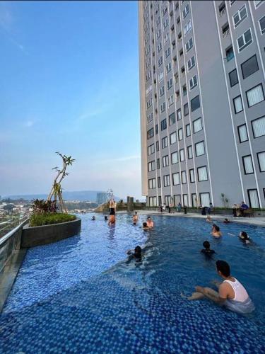 a group of people in a swimming pool in a building at Apartment The Bay AisBeLL in Kuala