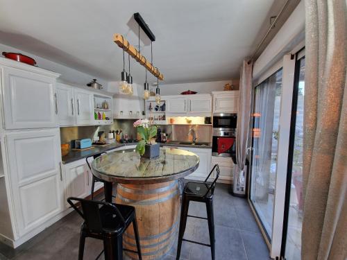 une cuisine avec une table tonneau et des chaises à l'intérieur dans l'établissement La maison du bonheur, à Caumont-sur-Durance