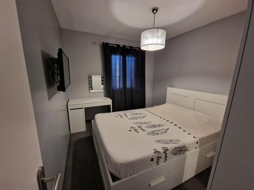 une petite pièce avec un lit et une fenêtre dans l'établissement La maison du bonheur, à Caumont-sur-Durance