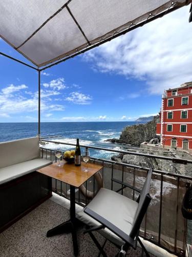 a table and chair on a balcony with a view of the ocean at Il mare in casa in Riomaggiore