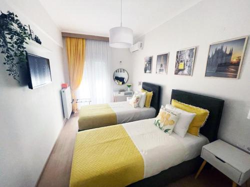 a bedroom with two beds with yellow and white at GetHome City Charm in Thessaloniki