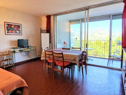 une salle à manger avec une table et des chaises et une grande fenêtre dans l'établissement Charmant T2 calme avec parking, ascenseur et loggia à Banyuls-sur-Mer - FR-1-309-12, à Banyuls-sur-Mer