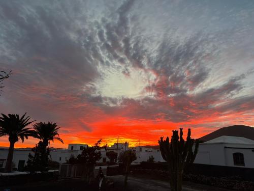 a cloudy sky at sunset with palm trees and buildings at Casa Carla in La Vegueta