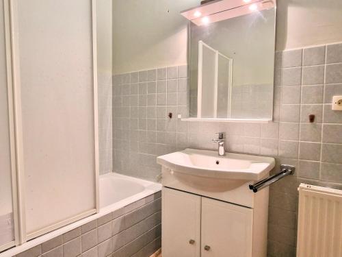 une salle de bain avec un lavabo, un miroir et une baignoire dans l'établissement Charmant T2 calme avec parking, ascenseur et loggia à Banyuls-sur-Mer - FR-1-309-12, à Banyuls-sur-Mer