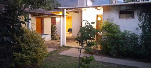 a small white house with yellow doors and a yard at Casa los abuelos cerca de la playa los Salpores in Panajachel