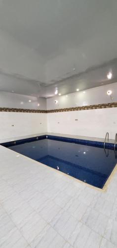 una piscina en medio de una habitación en استراحات توليب أبها, en Qāʼid