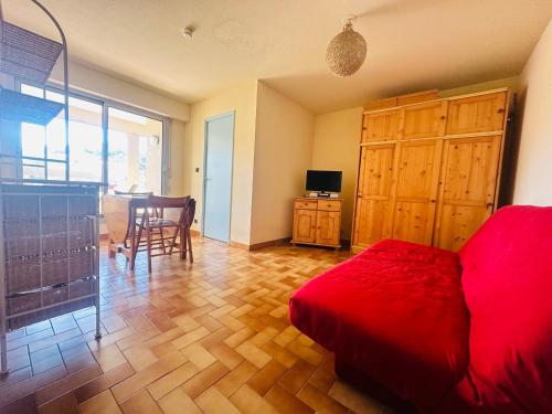 - une chambre avec un lit rouge et du parquet dans l'établissement Port-Vendres: T2 4 pers ascenseur, loggia ensoleillée, près des commerces - FR-1-309-188, à Port-Vendres