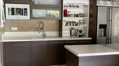 une cuisine avec un évier et un réfrigérateur dans l'établissement Maison AdriAnna, à Vedène