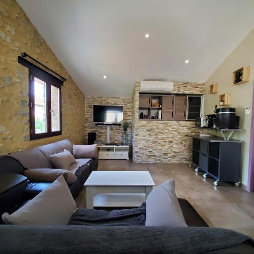 un salon avec un canapé et une table dans l'établissement Entre Mer & Montagne - Location du Samedi au Samedi uniquement - rental only from Saturday to Saturday, à Laurens
