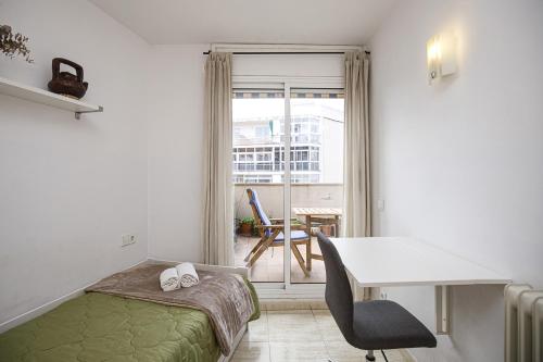 1 dormitorio con cama, escritorio y mesa en Apartamento con dos grandes terrazas en Girona, en Girona