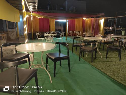 新德里的住宿－Nidra Hotel，用餐室配有桌椅和灯光