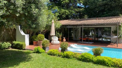 une cour avec une piscine et un parasol dans l'établissement Maison AdriAnna, à Vedène