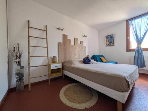 a bedroom with a large bed and a ladder at Appartement T2 à Collioure avec Terrasse et Parking Privé, à 300m de la Plage - FR-1-309-385 in Collioure