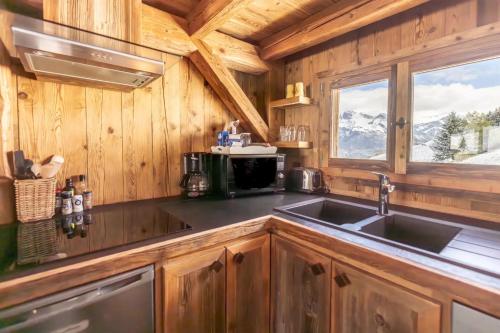 - une cuisine avec un évier dans une cabane en bois dans l'établissement Mazot de Warens, à Combloux