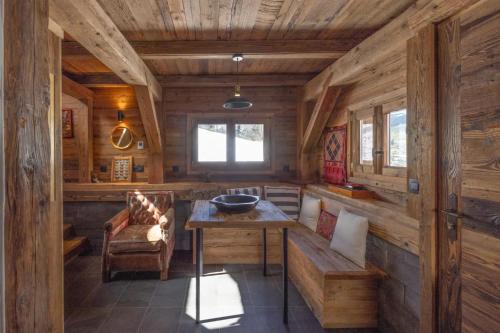 a room with a table and a bench in a cabin at Mazot des aravis in Combloux
