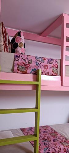 a bunk bed with a green ladder and a pink bunk bed at Riad SULTANA lateral seaview in Saidia 