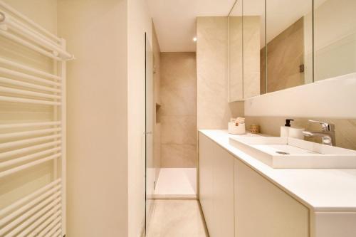 une salle de bain blanche avec un lavabo et un miroir dans l'établissement Grenoble/Appt moderne 2min gare et Hypercentre, à Grenoble