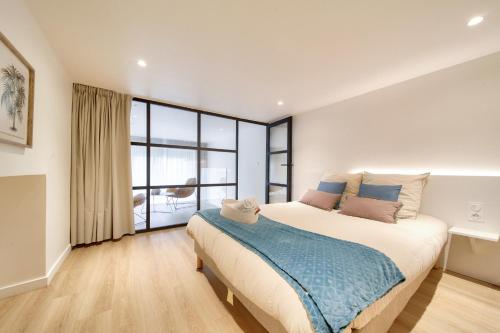 une chambre avec un grand lit et une grande fenêtre dans l'établissement Grenoble/Appt moderne 2min gare et Hypercentre, à Grenoble