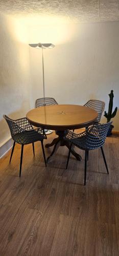 einen Holztisch und Stühle mit einem Tisch und einer Lampe in der Unterkunft L'appart - Couvet in Couvet