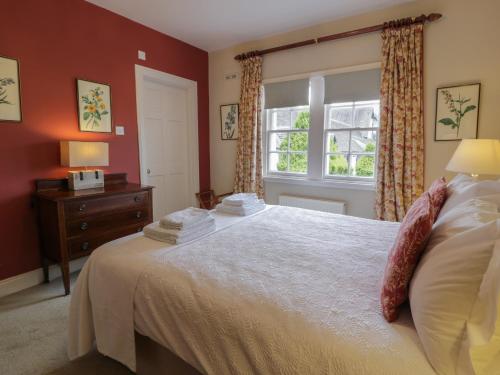 een slaapkamer met een groot bed en een raam bij Fordie East Cottage in Crieff