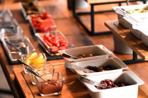 a wooden table topped with bowls of food and drinks at Pensiunea SEPTEMBRIE in Eşelniţa