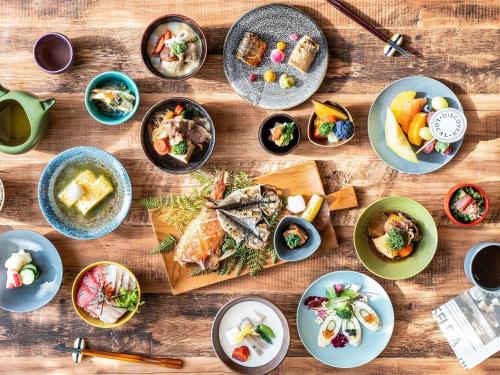 a wooden table with plates of food on it at Mercure Urabandai Resort & Spa in Kitashiobara