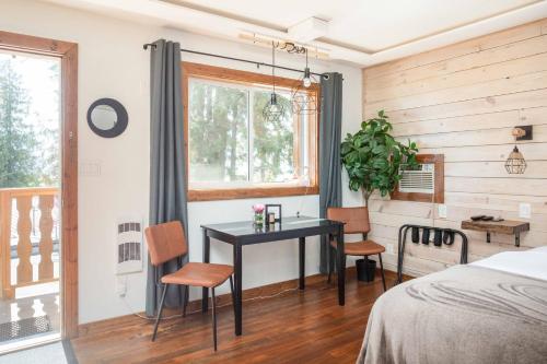 Schlafzimmer mit einem Schreibtisch, einem Bett und einem Fenster in der Unterkunft The Valley View in Creston