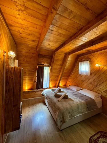 ein Schlafzimmer mit einem großen Bett in einem Holzzimmer in der Unterkunft Guesthouse Prrockaj Theth in Theth