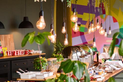 a kitchen with lights hanging above a table with plants at Pensiunea SEPTEMBRIE in Eşelniţa
