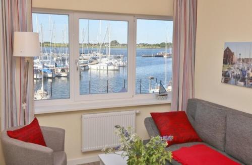 uma sala de estar com um sofá e uma janela com barcos em Am Rundsteg 7 em Burgtiefe auf Fehmarn 