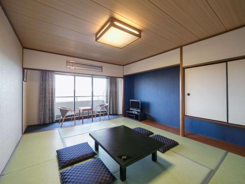 a living room with a table and chairs and a table at Mercure Kochi Tosa Resort & Spa in Geisei