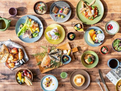 a wooden table with plates of food on it at Mercure Wakayama Kushimoto Resort & Spa in Kushimoto