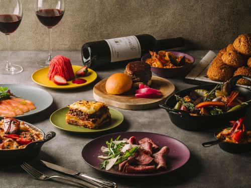 stół z talerzami jedzenia i kieliszkami wina w obiekcie Grand Mercure Ise-shima Resort & Spa w mieście Shima