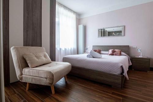 a bedroom with a bed and a chair and a mirror at Il Bosco di Silvia in Bosco