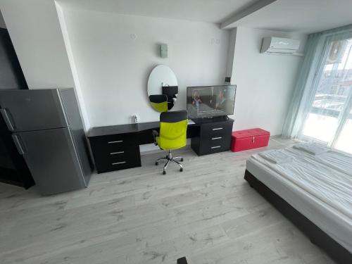 ein Schlafzimmer mit einem Schreibtisch und einem gelben Stuhl in der Unterkunft Day Dream in Burgas City