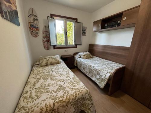 1 dormitorio con 2 camas y ventana en Casa Finca Patelo, en Bergondo