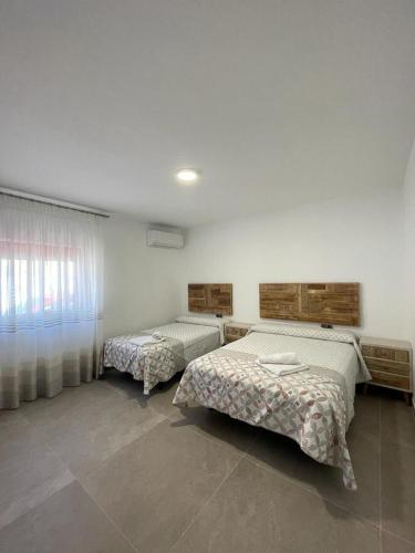 a bedroom with two beds and a window at Casa Javi y Carmen in Coto Rios