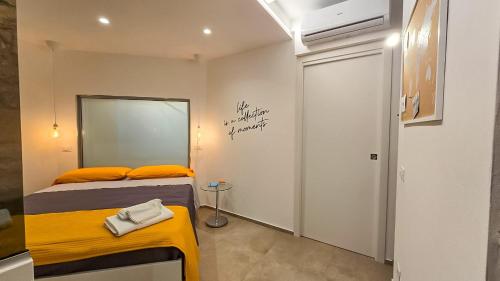 a bedroom with a bed with orange pillows and a mirror at Airam in Cefalù