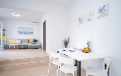 a white living room with a white table and chairs at Apartment Marin - ZF Hvar in Vrboska