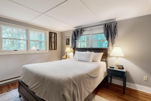 1 dormitorio con 1 cama grande y 2 ventanas en Boothbay Blue, en Boothbay Harbor