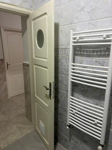 een badkamer met een witte deur en een douche bij Yassine's home in Jijel