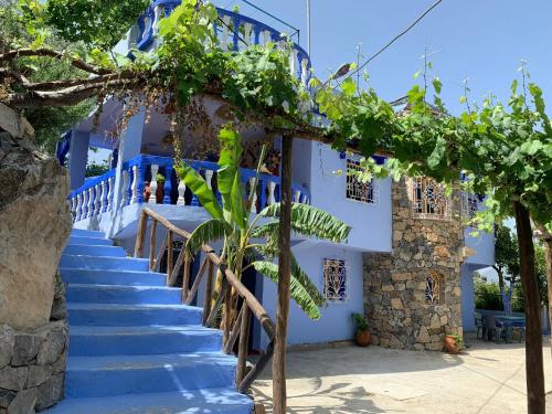 a staircase leading up to a white building with trees at Blue House Town in Chefchaouene