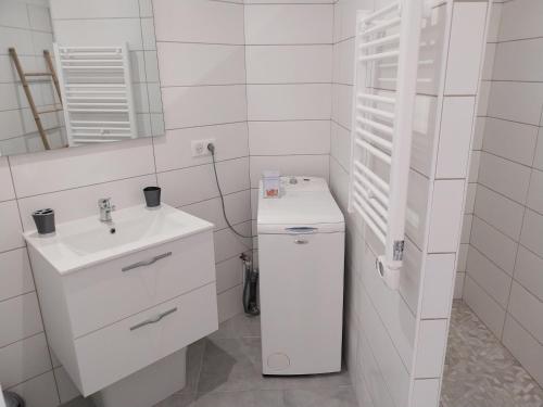 une salle de bain blanche avec un lavabo et un miroir dans l'établissement Magnifique appartement entre mer et montagne, à Tiuccia