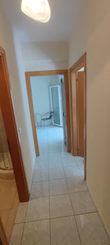 a hallway with a room with a table and a chair at Stella apartments in Olympiaki Akti