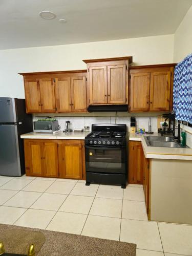 a kitchen with wooden cabinets and a black stove at Cozy one bedroom apartment in Lambeau