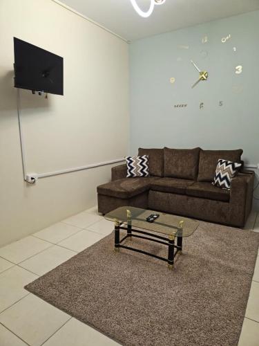 a living room with a couch and a clock on the wall at Cozy one bedroom apartment in Lambeau