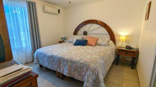 Un dormitorio con una cama grande con almohadas. en Condominio La Marina, en Puerto Vallarta