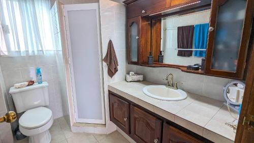 y baño con aseo, lavabo y espejo. en Condominio La Marina, en Puerto Vallarta