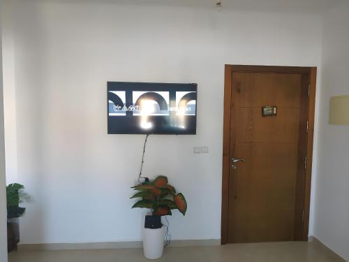 uma televisão pendurada numa parede ao lado de uma porta em Family Apartment By the Beach With a Pretty View em Oued Laou